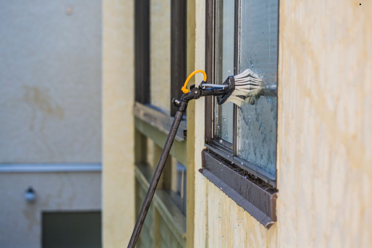 A window cleaning machine is actively cleaning a large window, showcasing its efficiency and effectiveness in window maintenance.