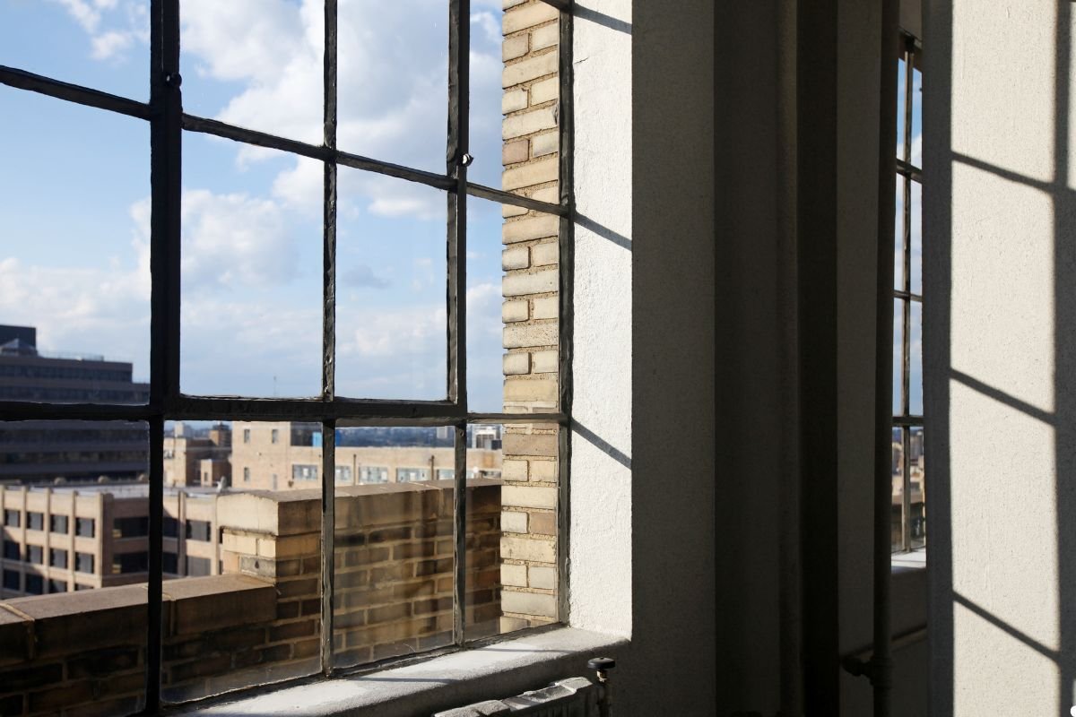 A window showcasing a panoramic view of a bustling city skyline under a clear blue sky.